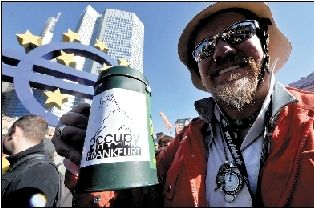 ▲15日，在德国法兰克福，抗议者高举口号在欧洲中央银行总部大楼前参加“占领法兰克福”活动，声援美国“占领华尔街”活动。新华社发